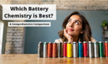 A woman sitting at a table with a line of colored batteries looking up with a questioning look on her face.